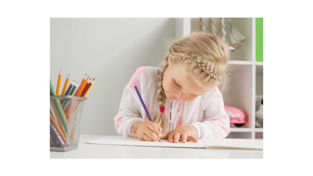 A young girl with braided hair is focused on coloring in a notebook on a table, surrounded by a container of colored pencils.